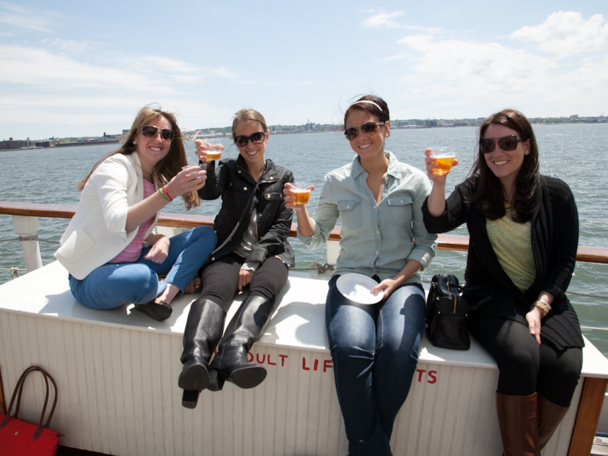 a group of people sitting on a bench next to a body of water